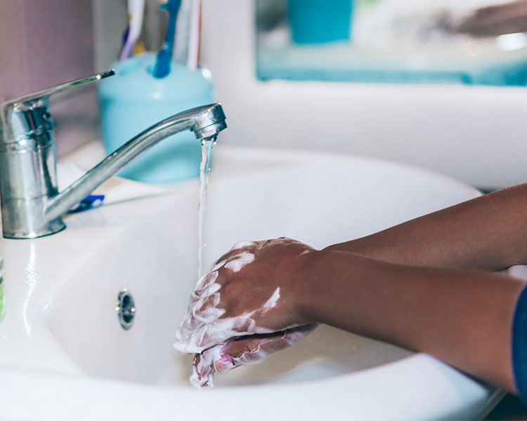 A boy washes his hands with soap.