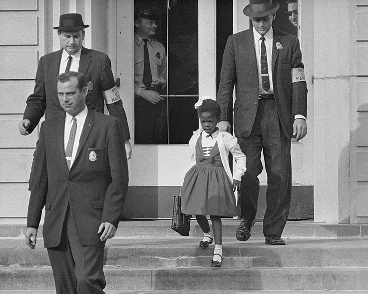 A young African American Girl guarded by Federal agents at school.