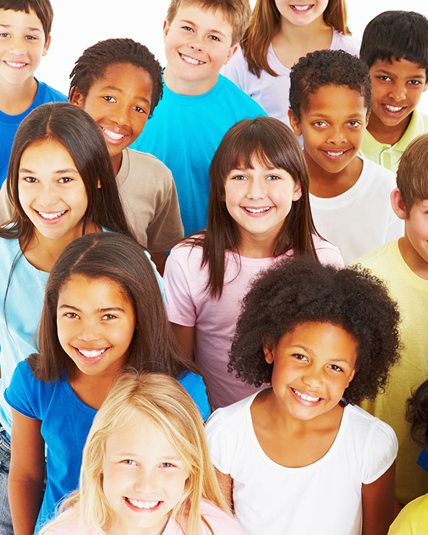 A dozen kids with different skin colors smile.
