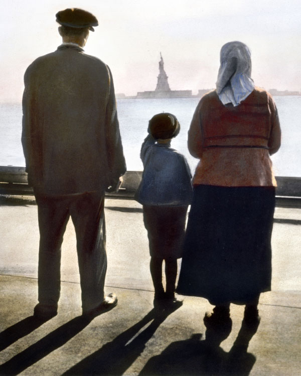 A mother, father, and child look at the Statue of Liberty.