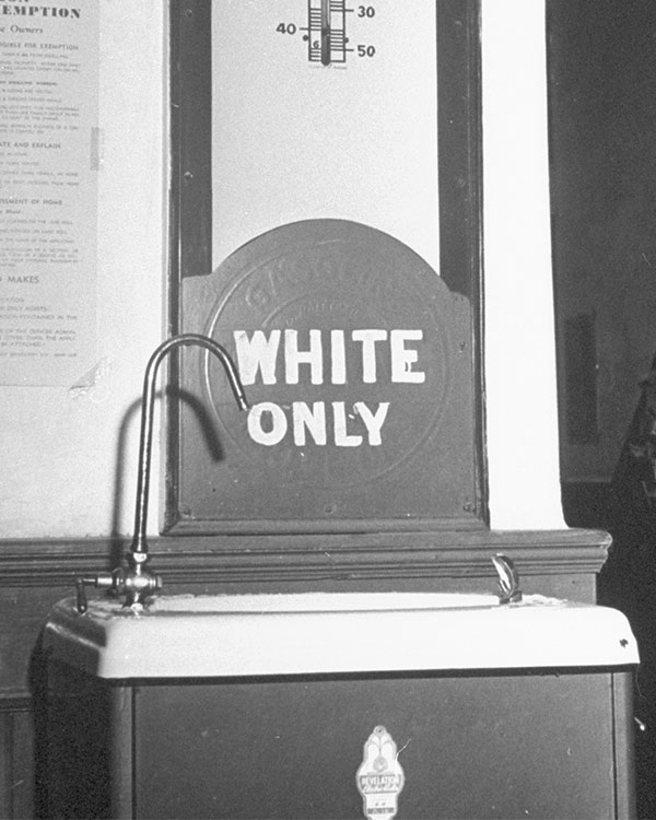 Black & white photo of a segregated sink. Text reads: white only