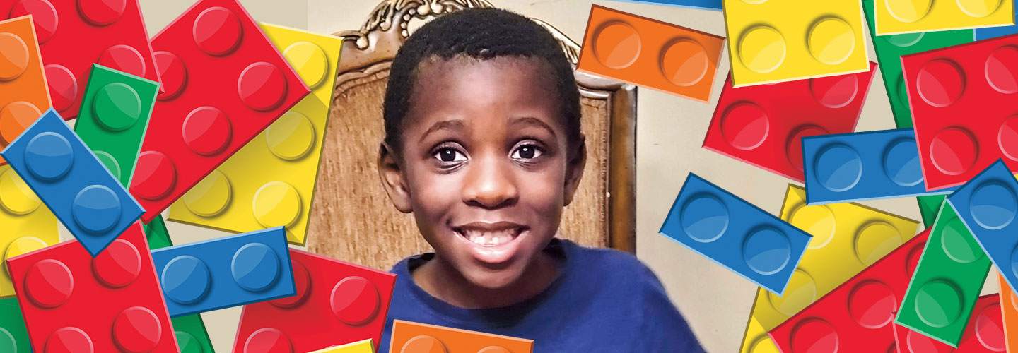 Dauda Sesay smiles while surrounded by Legos