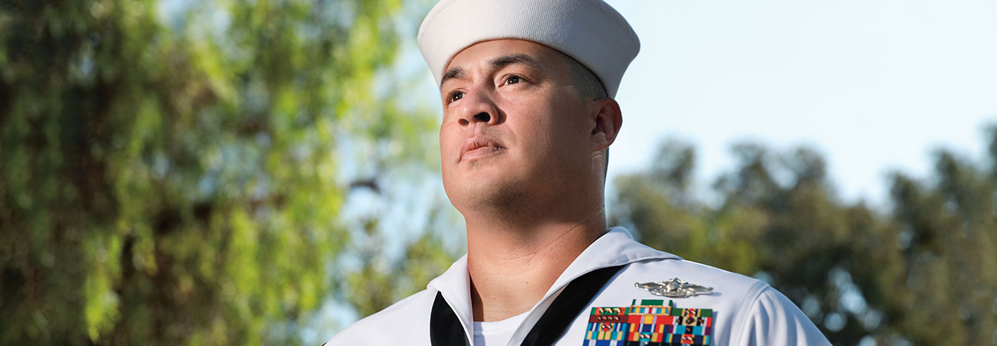 A man in a white sailor uniform with badges on it