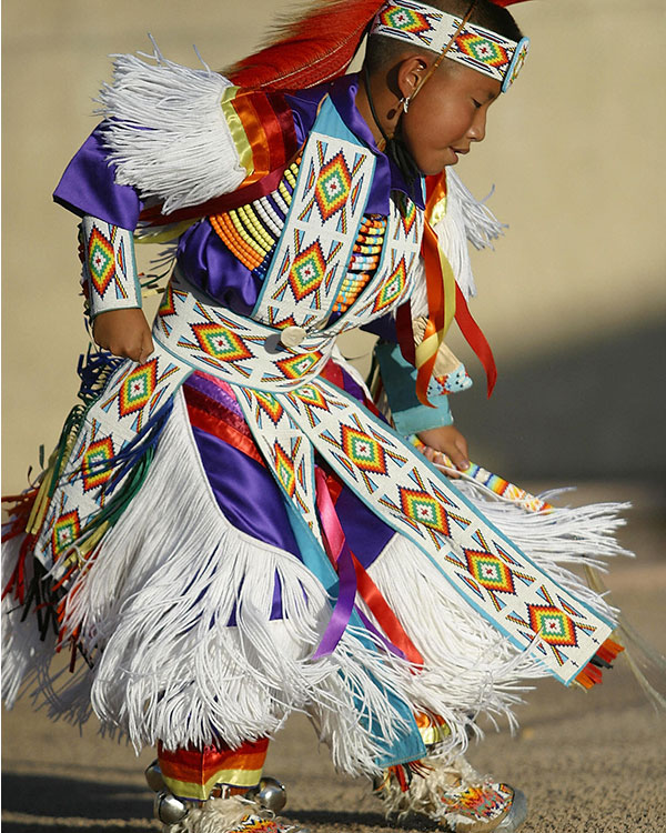 Kid wearing traditional Native dancing clothes