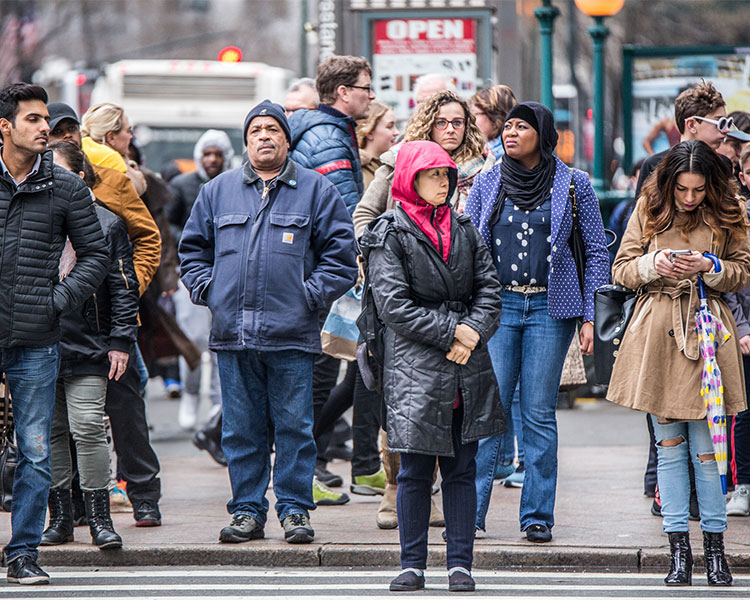 A variety of people walking on a busy city street