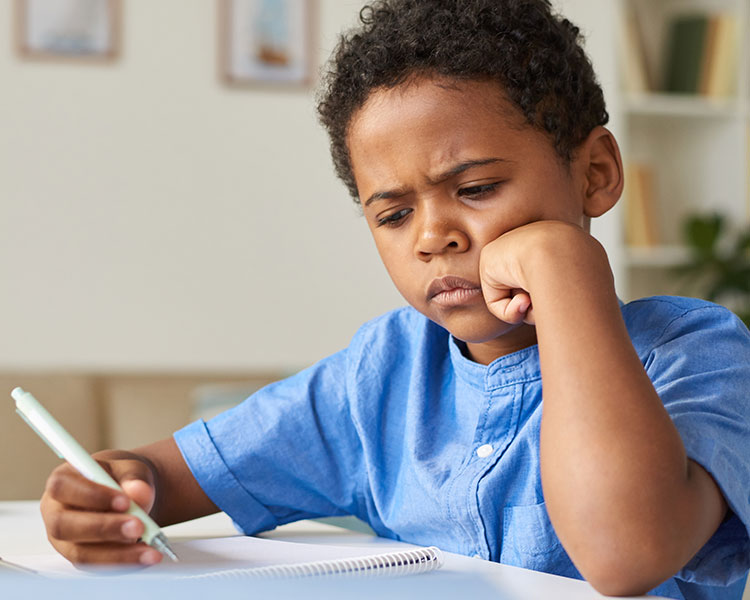 Photo of a student holding a pen and wearing a confused expression