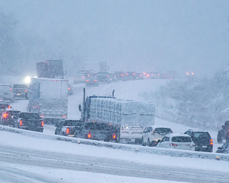 Image of snow coming down a busy highway