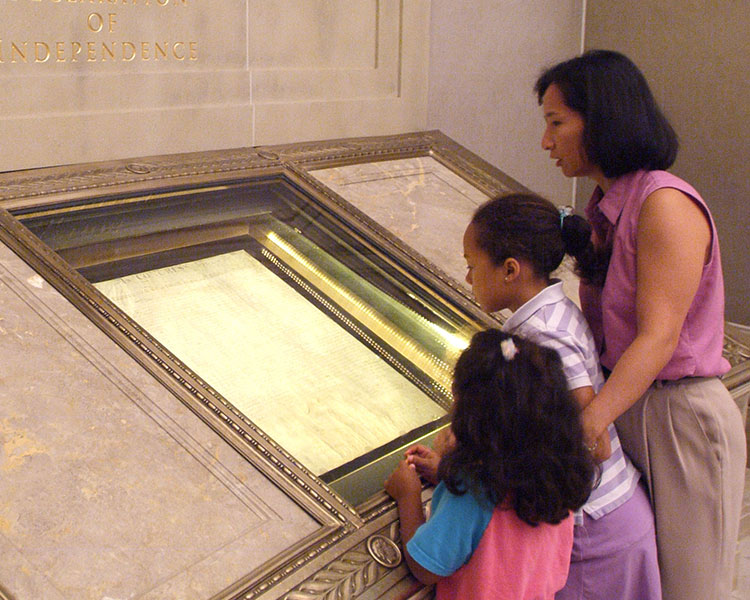 Photo of people looking at official documents in a museum