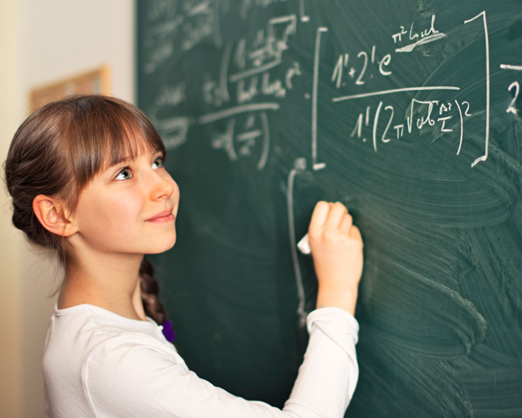 Photo of a student writing math equations on a chalkboard