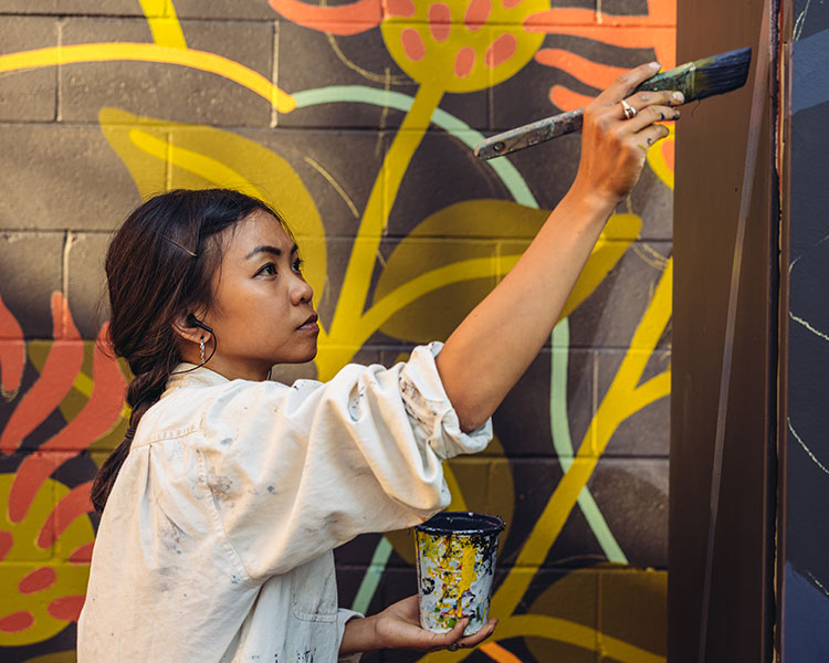 Photo of a person painting a mural