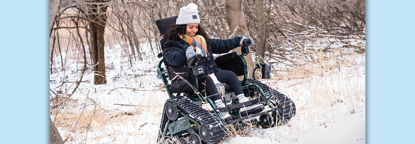 Photo of a person riding a wheelchair that can access different landscapes such as a snow