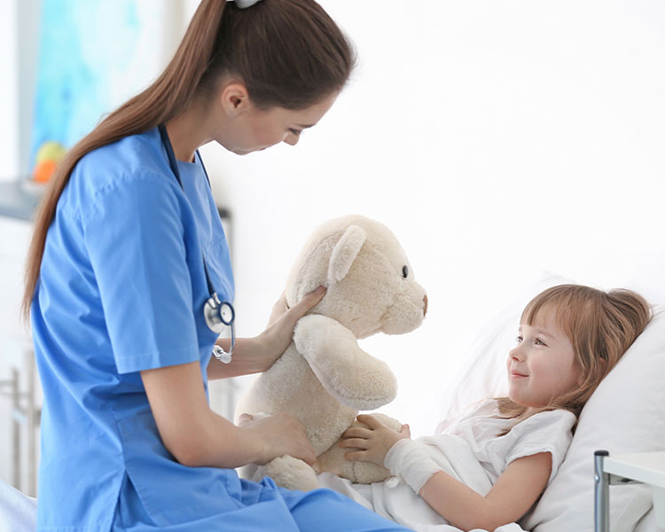 Nurse holding a teddy bear in front of a patient