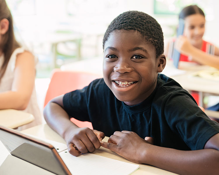 Student smiling at their desk