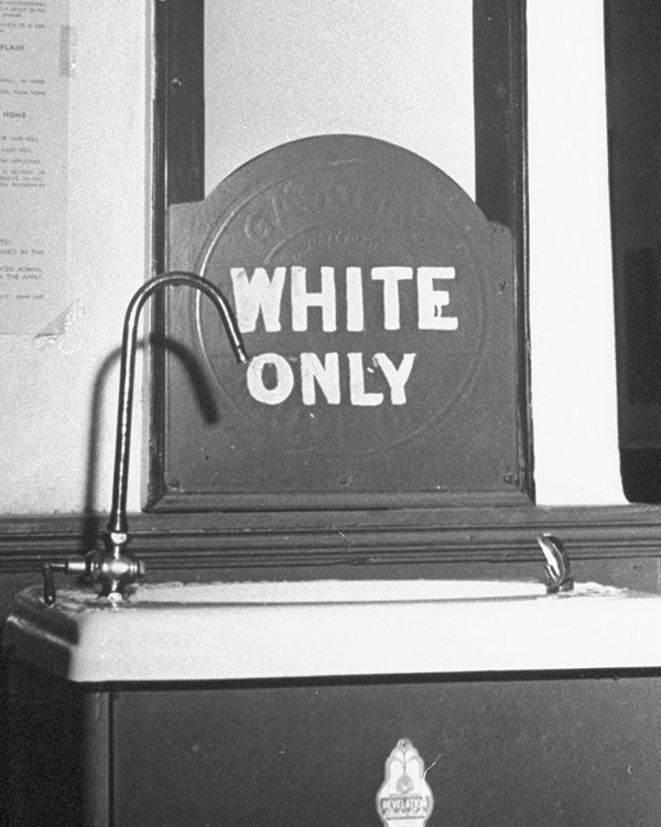 Black & white photo of a sink labeled, "White Only"