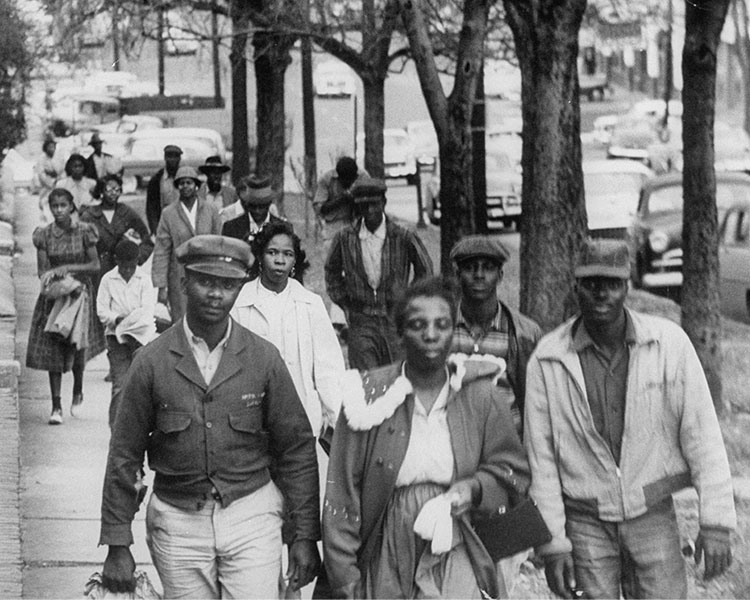 Black & white photo of Black Americans participating in a bus boycott by walking instead