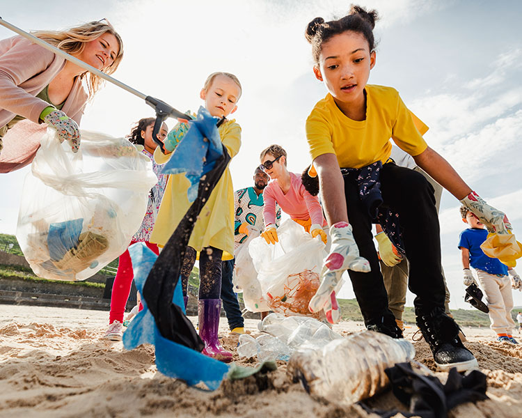 Photo of kid volunteers picking up trash on the beach