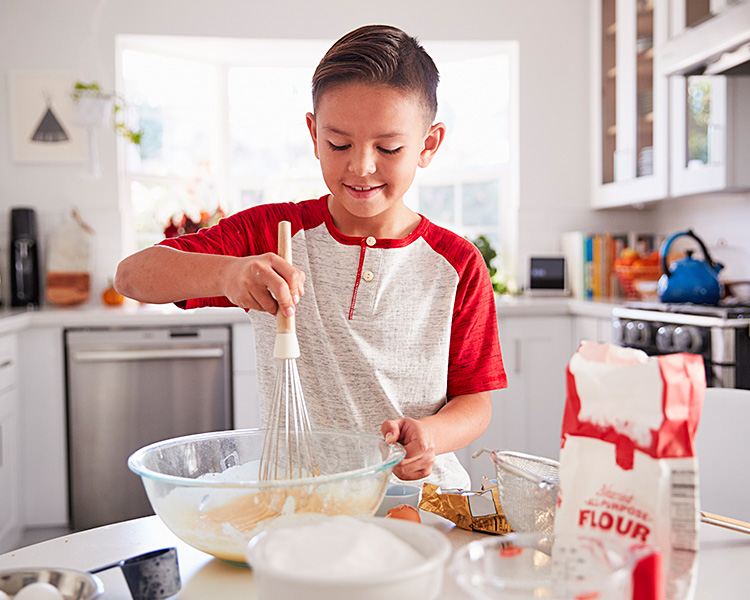 Image of a kid whisking ingredients together in a bowl