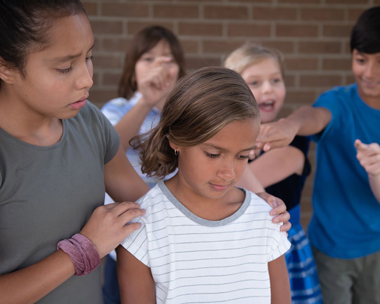 Image of a student being bullied while another student steps in to console her