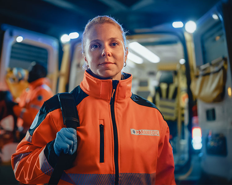 Image of a paremedic standing in front of an ambulance