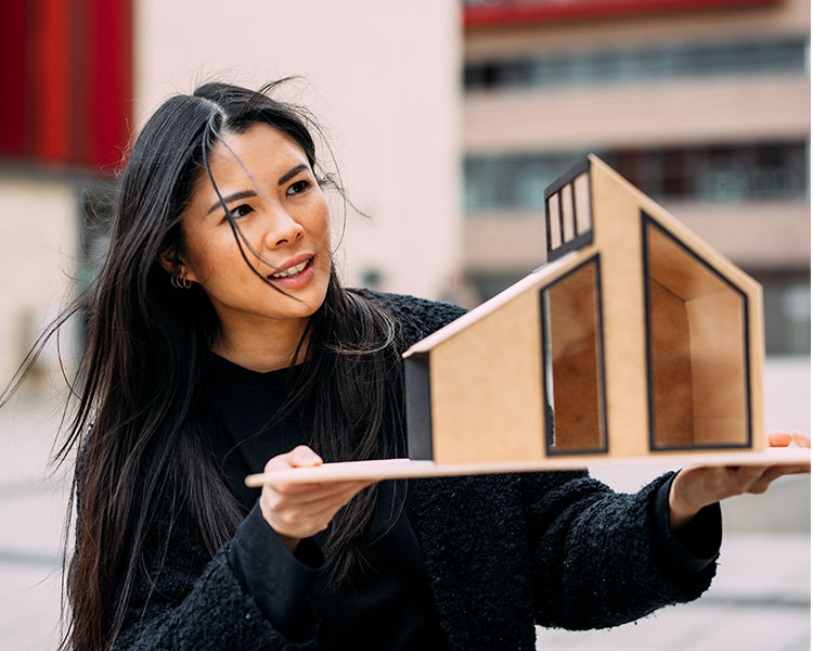 Photo of a person holding a model house