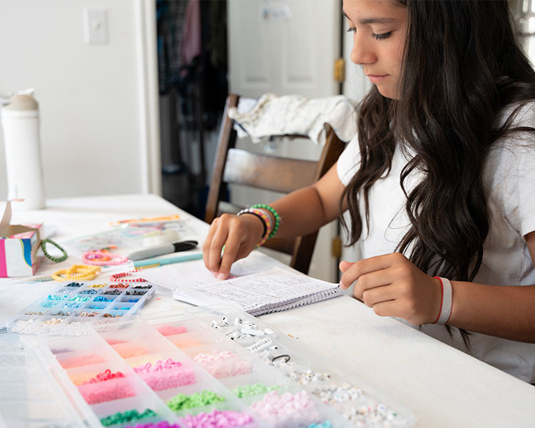 Photo of a kid creating their own bead bracelets